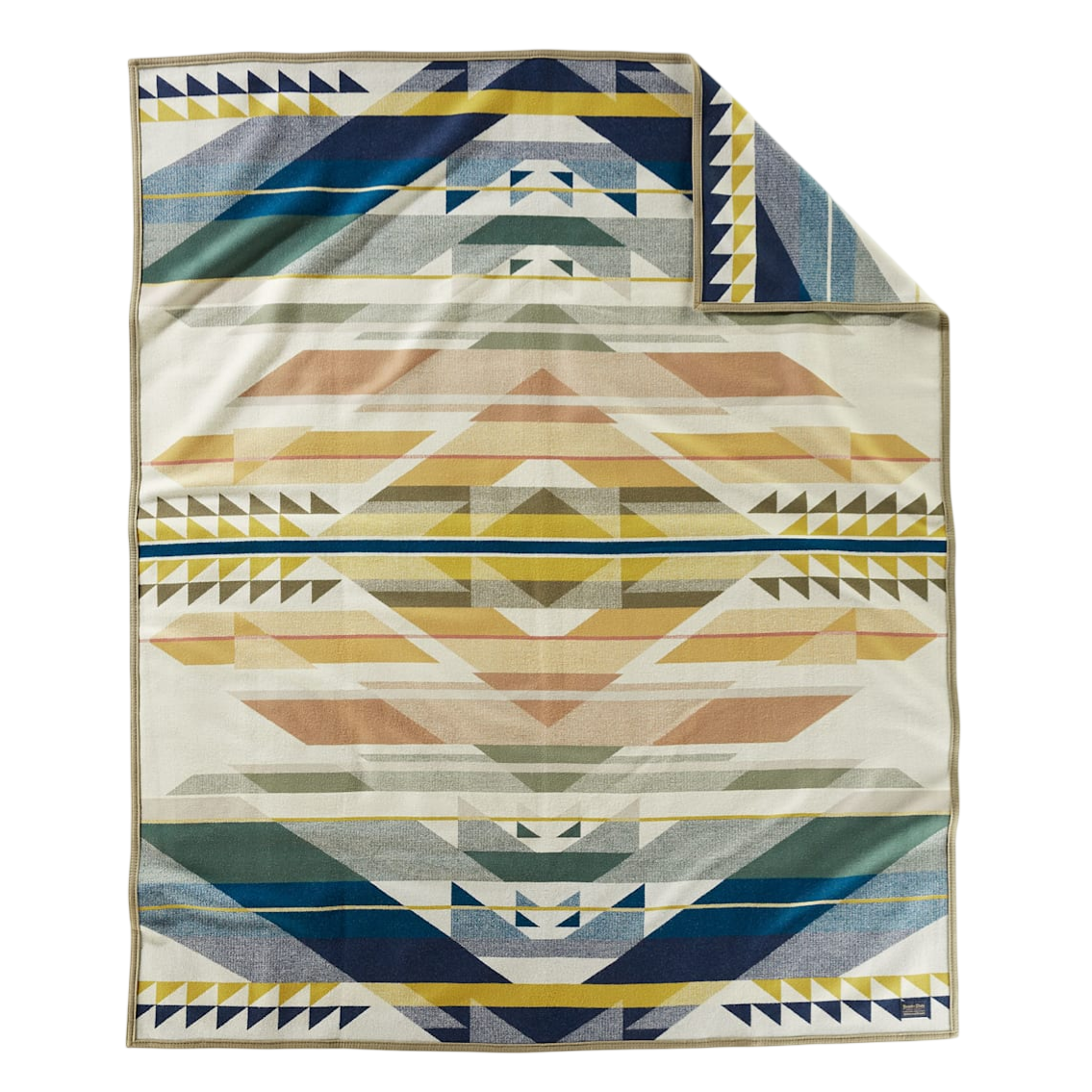 A blanket featuring a geometric, multicolored pattern with triangles and stripes in shades of blue, yellow, and earthy tones.