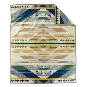 A blanket featuring a geometric, multicolored pattern with triangles and stripes in shades of blue, yellow, and earthy tones.