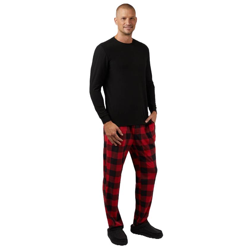 The man is wearing a 32 Degrees Sleep Set, featuring a black long-sleeve top and red-and-black checkered pajama pants.