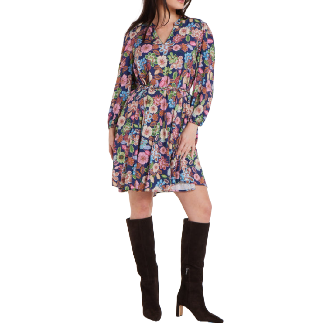 Floral mini dress with a colorful pattern, featuring long sleeves, a V-neckline, and a belted waist for a flattering fit. Paired with knee-high black boots.