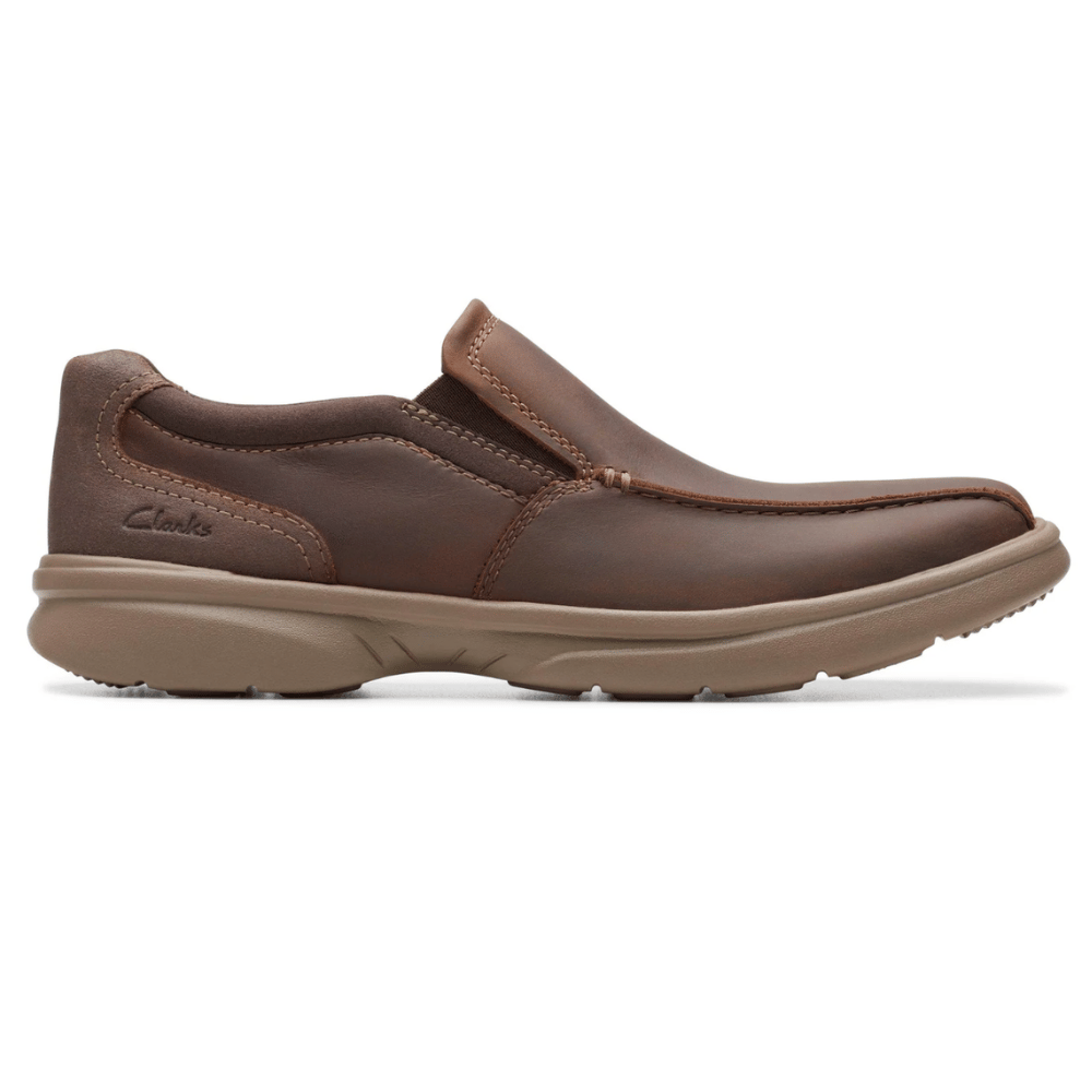 Brown leather slip-on shoe with a thick rubber sole, designed for casual wear. Features visible stitching and a low-profile design.
