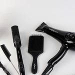 A variety of hair styling tools including a hairdryer, straightener, curling wand, and brushes.