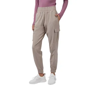 Tan cargo joggers with an elastic waistband and cuffs, paired with a long-sleeve mauve top and white athletic sneakers.