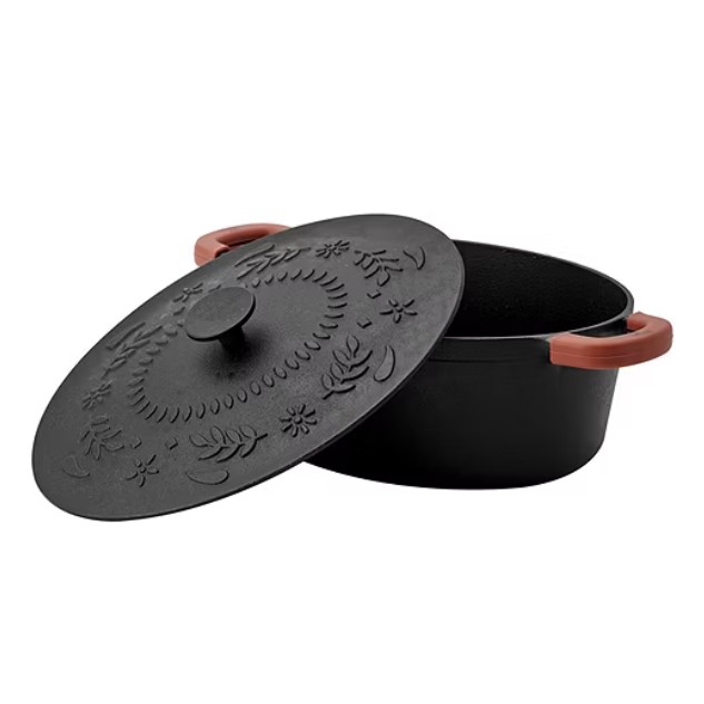 Cast iron Dutch oven with a decorative lid and side handles.