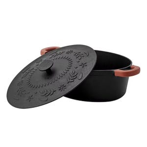 Cast iron Dutch oven with a decorative lid and side handles.