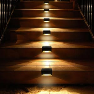 Staircase with installed LED stair lights providing illumination on each step.