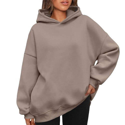 A person wearing a plain beige hoodie with a front pouch and a hood.