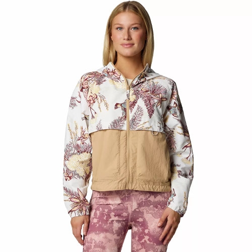 A woman is wearing a two-tone jacket with a floral pattern on the upper half and solid tan on the lower half, paired with pink textured leggings.