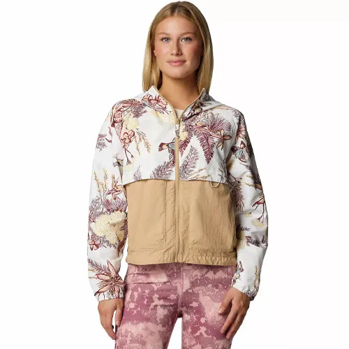 A woman is wearing a two-tone jacket with a floral pattern on the upper half and solid tan on the lower half, paired with pink textured leggings.