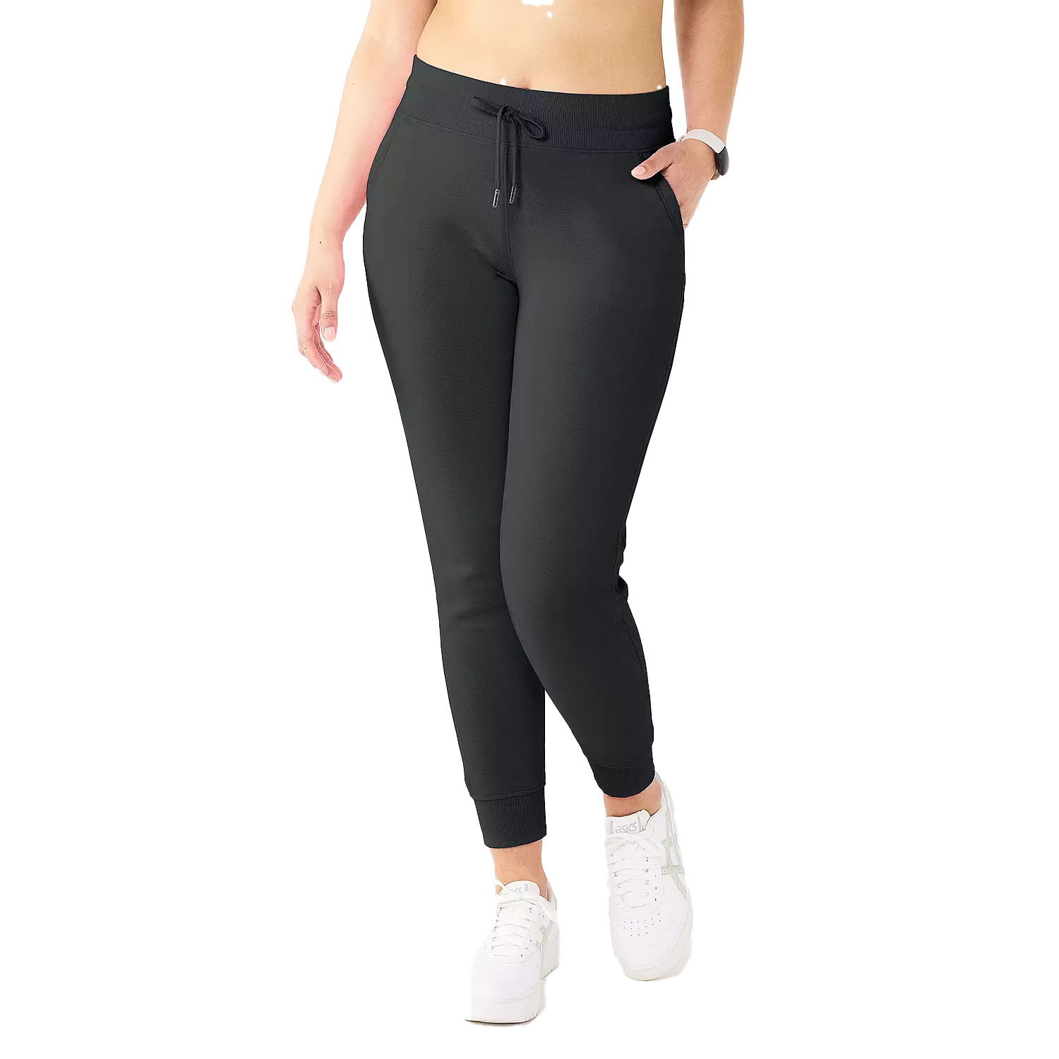 Tek Gear Fleece Joggers are black, high-waisted with a drawstring, featuring side pockets and ribbed cuffs. Paired with white athletic shoes, they offer a comfortable and sporty look.