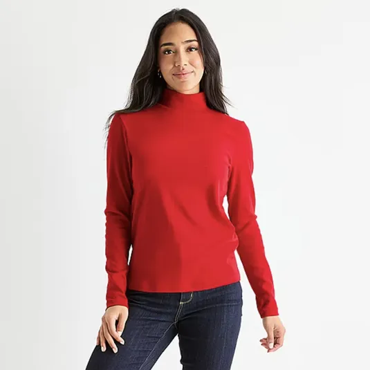 A woman is wearing a long-sleeve red turtleneck shirt paired with dark blue jeans.