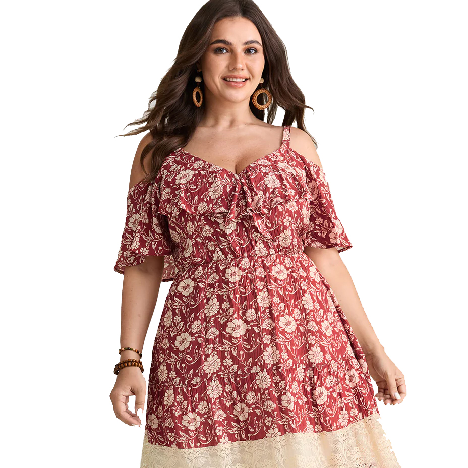 A woman wearing a red floral off-shoulder dress with ruffle detailing and a beige lace hem. She accessorizes with hoop earrings and a bracelet.