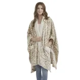 A person is wearing a leopard print fleece shawl with pockets over a white top and blue jeans, standing barefoot.