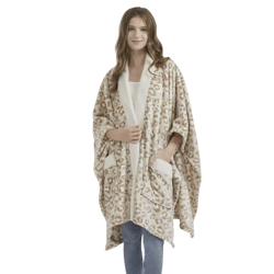 A person is wearing a leopard print fleece shawl with pockets over a white top and blue jeans, standing barefoot.