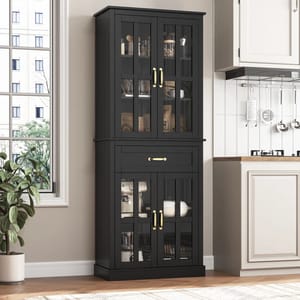 A black 71\“ tall kitchen pantry with glass-paneled double doors, brass handles, and an upper drawer. It features wooden construction and is adjacent to a kitchen countertop, blending storage and display for kitchen items.