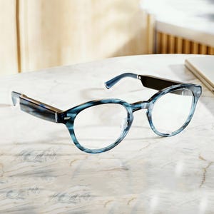 The Amazon Echo Frames are smart glasses featuring a sleek, lightweight design with built-in microphones for hands-free Alexa access. They have rectangular lenses and come in a stylish blue tortoiseshell pattern.