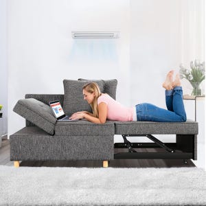 Modular gray sofa with storage compartment, featuring adjustable backrest; woman lying on it using a laptop.