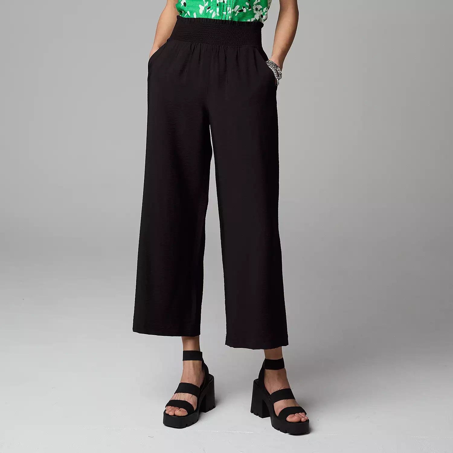 Black wide-leg trousers with an elastic waistband, paired with platform sandals.