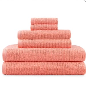 A stack of peach-colored towels in various sizes, neatly arranged from largest to smallest.