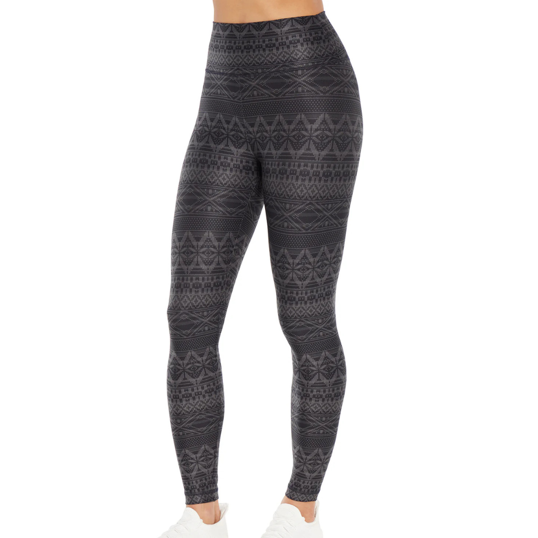 Black high-waisted leggings with a geometric tribal pattern, paired with white sneakers.