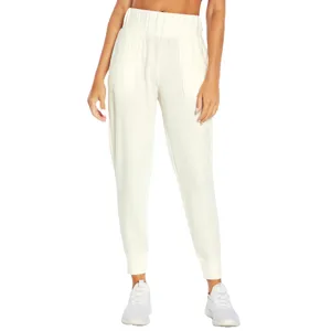 White jogger pants with a high waistband and cuffed ankles, paired with white sneakers.