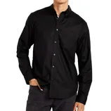 A person is wearing a black button-up shirt with a chest pocket and dark jeans.