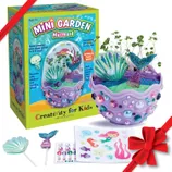 Kids' Terrarium Kit includes a mini garden set with seeds, colorful sand, stickers, and sparkly decorations. Designed for children ages 6+, the kit allows them to create and decorate a mermaid-themed terrarium that grows plants in 3-5 days.