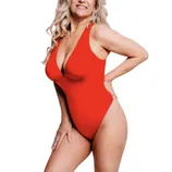 A woman is wearing a red one-piece swimsuit with a plunging neckline, showing a confident and stylish pose.