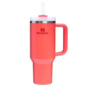 A pink Stanley stainless steel tumbler with a handle, featuring a straw and a lid.