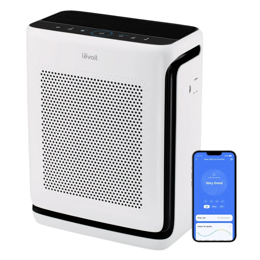 A Levoit air purifier with a white design and perforated front panel, shown alongside a smartphone displaying an app interface reading \“Very Good\“ for indoor air quality.