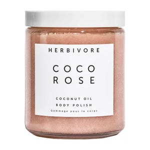 Herbivore Botanicals Coco Rose Coconut Oil Body Polish is a pink body scrub designed to exfoliate and moisturize the skin. It features coconut oil for hydration and has a rose scent.