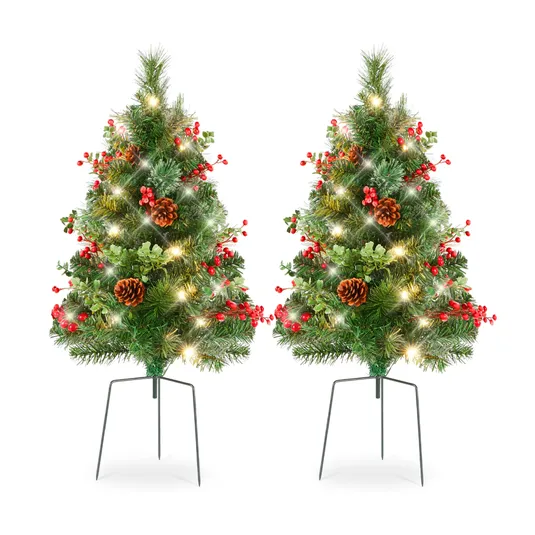 Two small artificial Christmas trees with lights, pine cones, and red berries, set on metal stands.