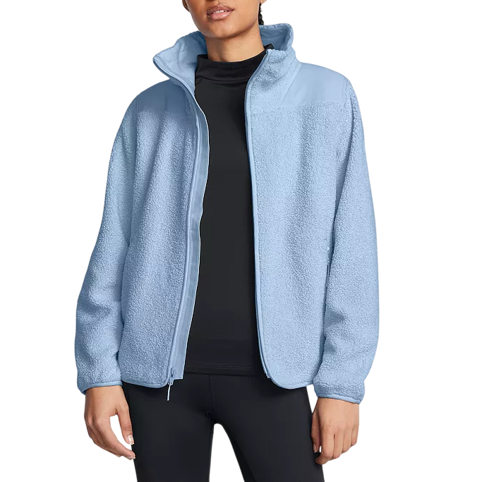 A person wearing a light blue fleece jacket over a black top and black leggings.