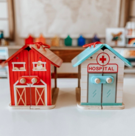 Two miniature buildings, a red barn and a blue-roofed hospital, likely intended as children's toys.