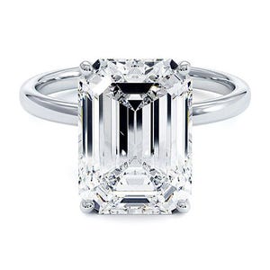 A ring featuring a large, rectangular emerald-cut diamond set on a simple metal band.