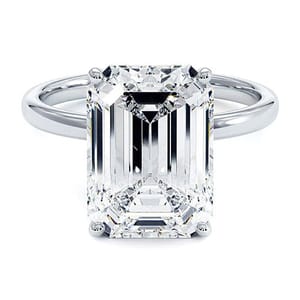 A ring featuring a large, rectangular emerald-cut diamond set on a simple metal band.