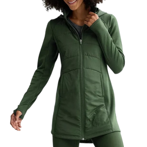 A person is wearing a long, green zip-up jacket with a fitted design, featuring a high collar and long sleeves. The outfit is complemented by matching green leggings.