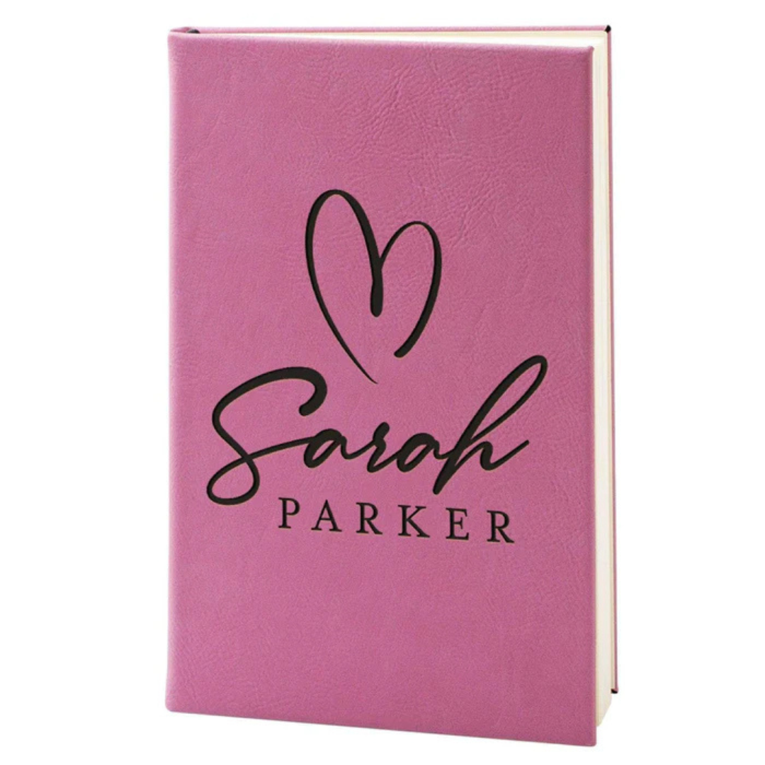 Pink journal with a heart design and \“Sarah Parker\“ printed in black lettering on the cover.