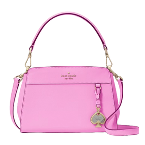 A bright pink Kate Spade leather satchel with a top handle and a detachable shoulder strap. It features gold-tone hardware, a logo on the front, and a spade-shaped charm.