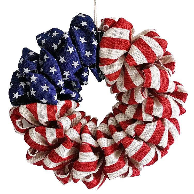 A round wreath made of burlap featuring the American flag design, with red and white stripes and a blue section with white stars.