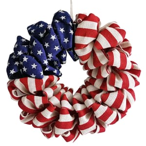 A round wreath made of burlap featuring the American flag design, with red and white stripes and a blue section with white stars.