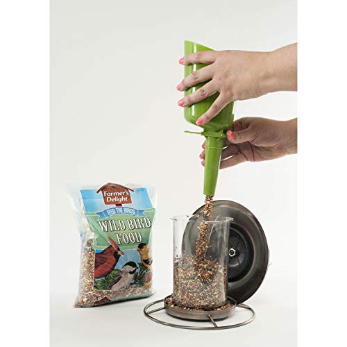 A bag of Wagner's Wild Bird Food next to a bird feeder being filled with seeds using a green funnel held by a person's hands.
