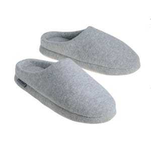 Kathy Ireland Clog Slippers are cozy, heather gray slip-ons with a closed toe design and soft fabric. They feature a subtle branded tag on the side for a simple, comfortable indoor footwear option.