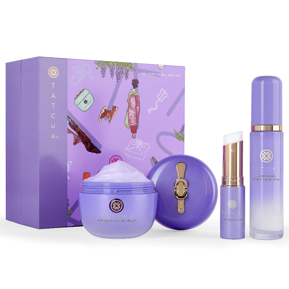 Tatcha gift set with Dewy Skin Cream, Luminous Dewy Skin Mist, and The Serum Stick, all in purple packaging with a decorative box.