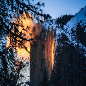 A natural phenomenon at Yosemite National Park, known as \“Firefall,\“ where the setting sun illuminates Horsetail Fall, creating an effect that resembles flowing lava.
