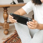 A person is holding a portable gaming console, ready to play.