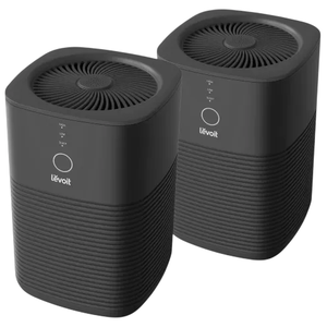 Two black Levoit air purifiers with a sleek design, featuring a circular display and top air vent pattern.