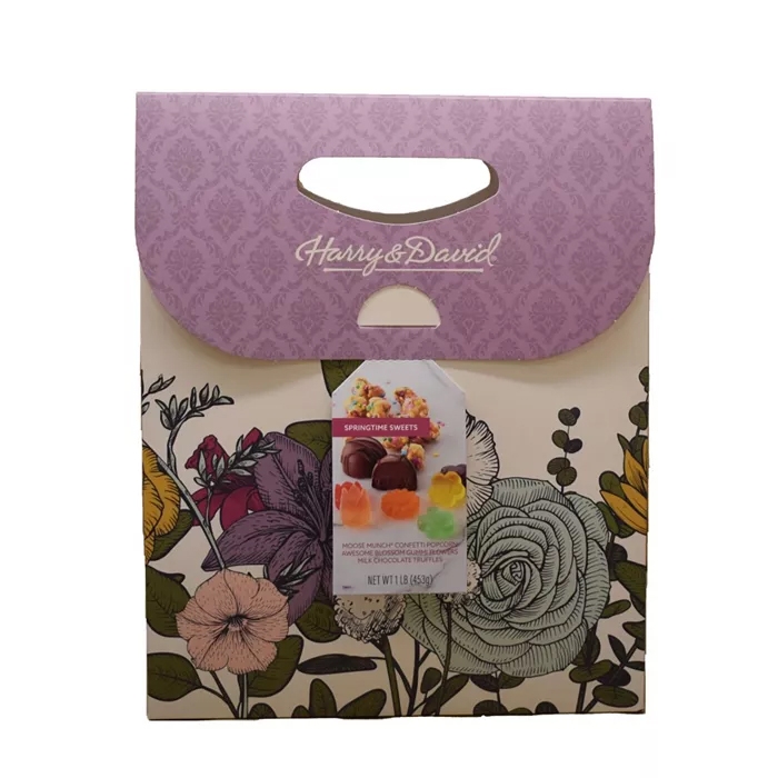 Harry & David gift package with a floral design and purple top includes Springtime Sweets: Moose Munch Confetti Popcorn and assorted chocolate truffles.