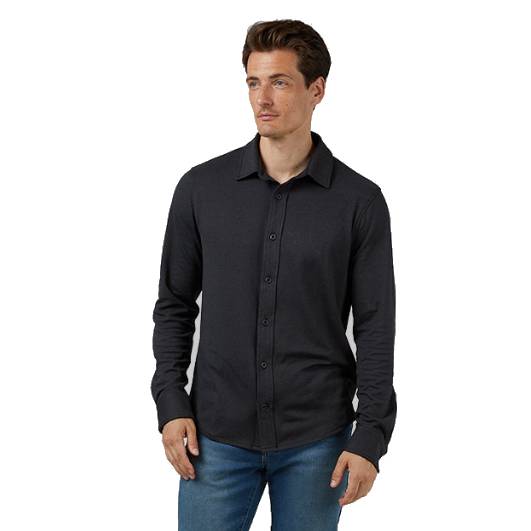 A man wearing a dark long-sleeve button-up shirt paired with blue jeans.