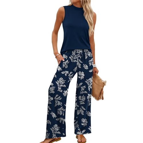 Sleeveless navy top paired with navy wide-leg pants featuring a white floral print, accessorized with a tan clutch and sandals.